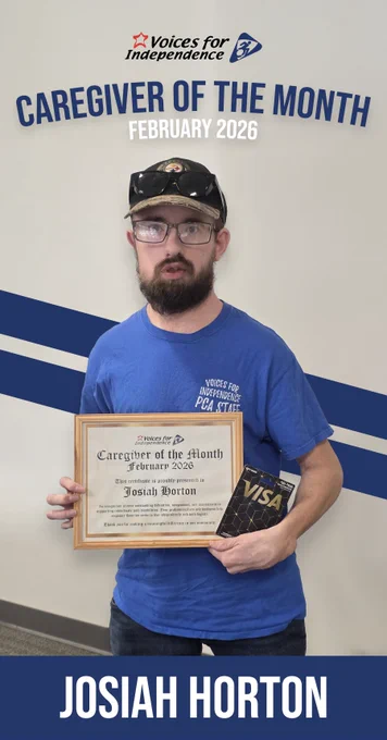 This is a photo of caregiver Josiah Horton, VFI (Erie Region) Caregiver of the Month for February 2026, holding a framed certificate of recognition and a Visa gift card. The VFI logo and "Caregiver of the Month" appears at top, along with the caregiver's name in white, atop a blue footer bar at bottom.