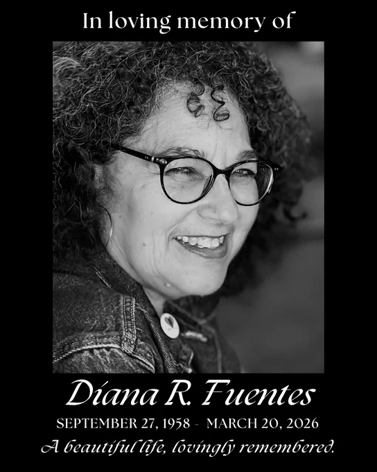 This is a memorial image featuring a smiling individual with curly hair and glasses. The text reads: "In loving memory of Diana R. Fuentes, September 27, 1958 - March 20, 2026. A beautiful life, lovingly remembered.