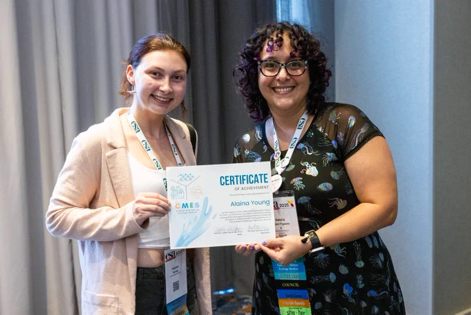 The chair of the Coastal & Marine Ecology Section presents an award certificate to a student at the 2025 Brackish Bash