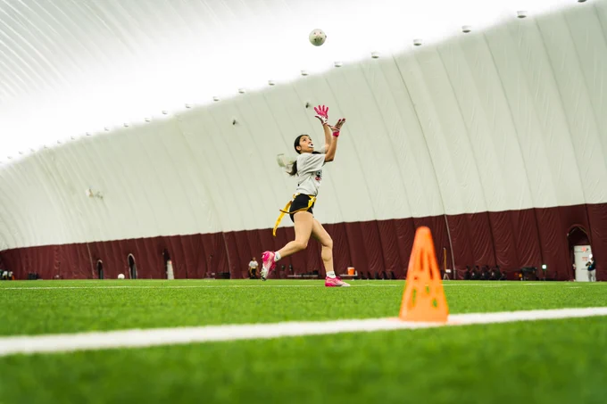 Photo of a Girls Flag player catching a football.