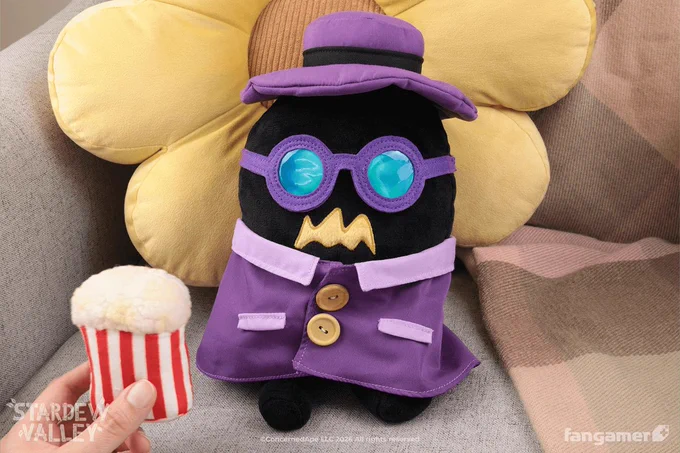 A photo of the Incognito Krobus plush sitting in an armchair, showing its discreet purple disguise. Someone is handing it a plush box of popcorn. 
