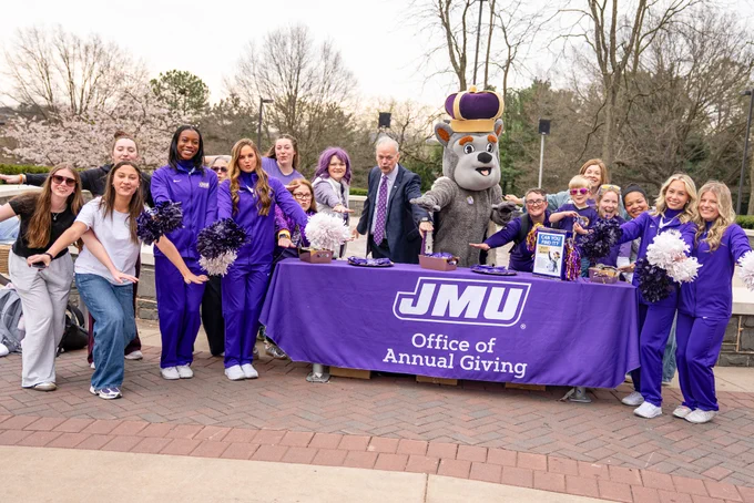 Duke Dog poses with a group of cheerleaders and students for Giving Day. 