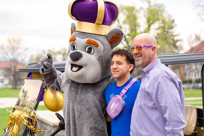 Duke Dog takes a photo with Dr.Miller and a student.