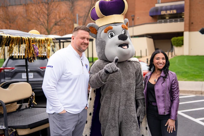 Duke Dog poses for a photo with Matt and Mallory Roan. 
