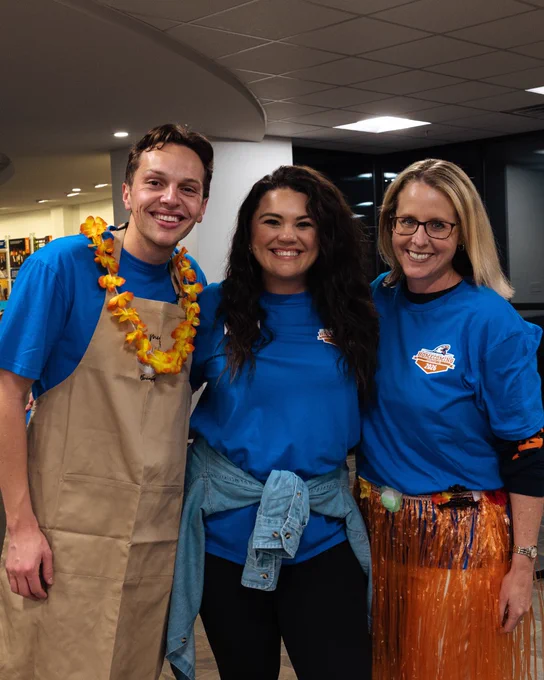 Two UTTyler employees posing with President Philley at Midnight Breakfast