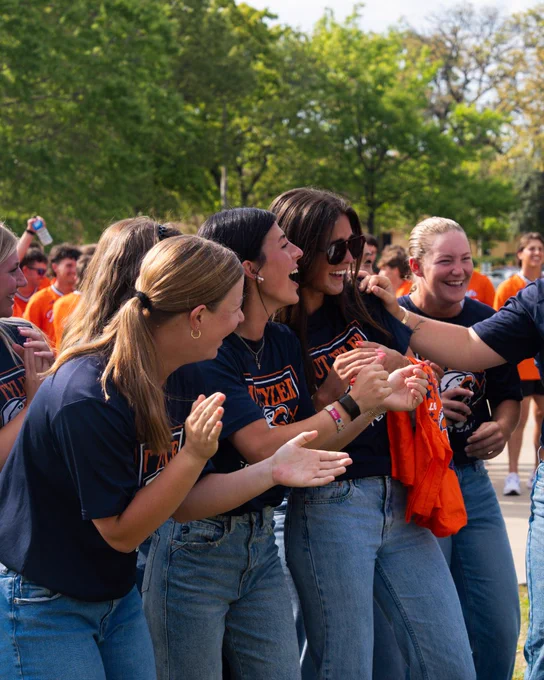 Three UTTyler softball players laughing at pep rally kick off