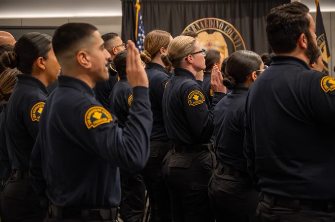 Officers raising their right hands as they take their oath during a swearing-in ceremony.