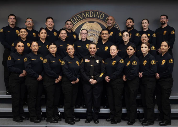 A group of probation corrections officers posing together for a graduation celebration photo.