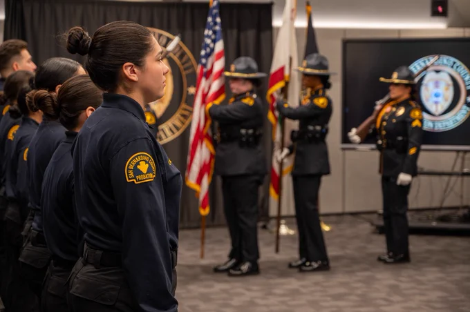 Honor guard officers standing at attention, along with probation corrections officers.