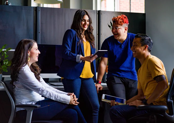 A diverse group of coworkers engaging in a discussion in a modern office environment