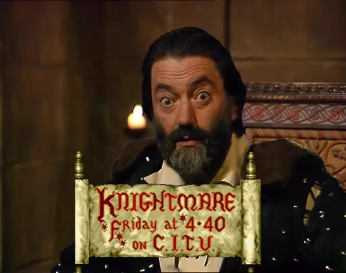 Knightmare Series 6: Treguard (Hugo Myatt) addresses the watchers behind an open scroll that reads:

Knightmare
Friday at 4.40
on C.I.T.V.