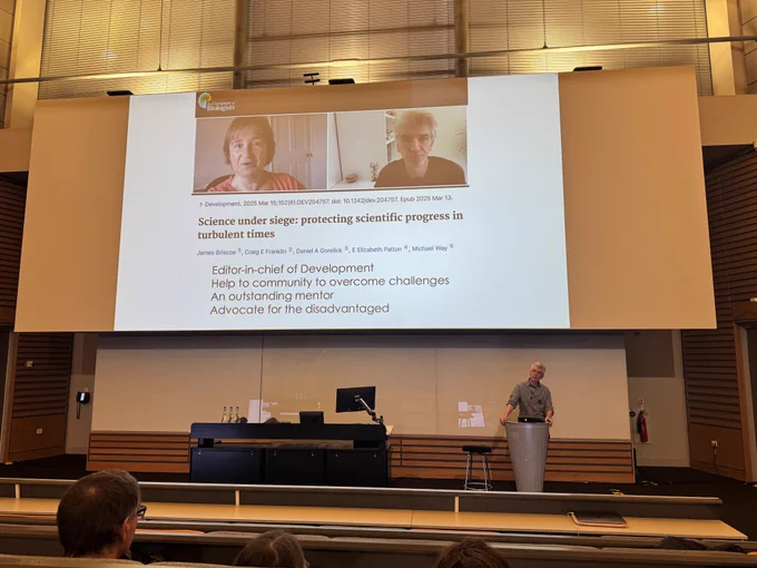 James Briscoe presenting in front of an auditorium. 