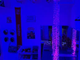 A room with blue walls and a purple bubble tube.