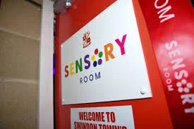 A sign with different colour wording on a red door.