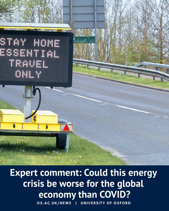 Roadside electronic sign displaying “Stay home, essential travel only” beside an empty road. Overlaid text reads: “Expert comment: Could this energy crisis be worse for the global economy than COVID?” with University of Oxford branding and link.