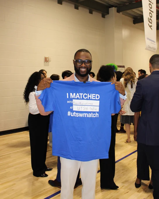 Ebuka Eziama holding a "I matched into Anesthesiology and UTSW" shirt