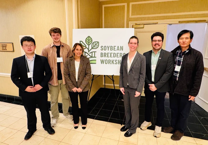The Zhang Lab with a Soybean Breeders Workshop poster. From left to right: Yaojie Zheng, Gordon Burton, Luciana Rosso, Virginia Claire Lehmann, Matheus Granja, and Muliang Peng.