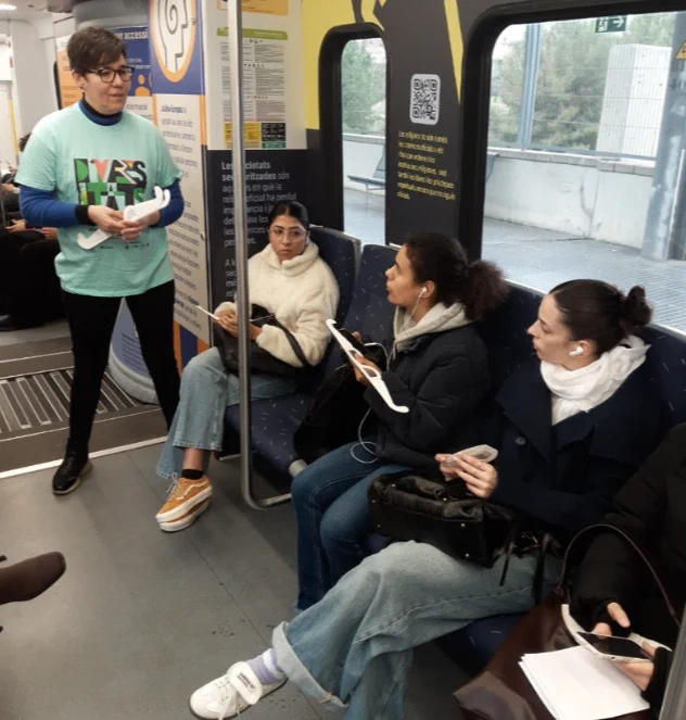 Estel·la Oncins parla amb passatgers que duen a les mans ulleres de simulació de baixa visió