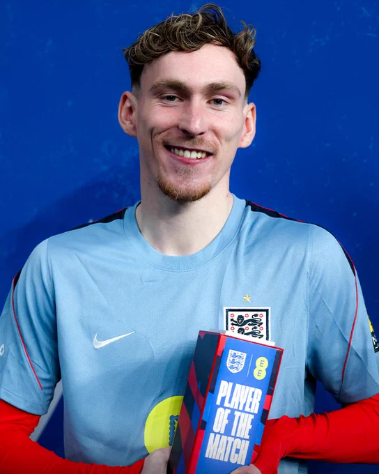 James Garner smiles while holding his Player of the Match trophy