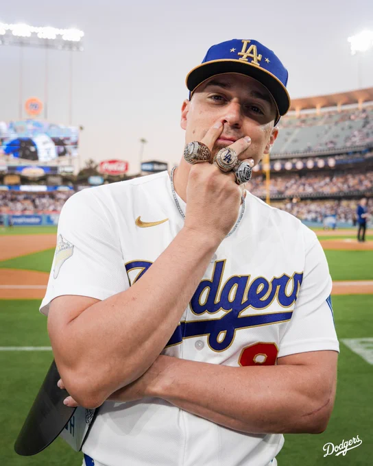 A photo of Kiké Hernández putting his hand to his face with his three World Series rings.