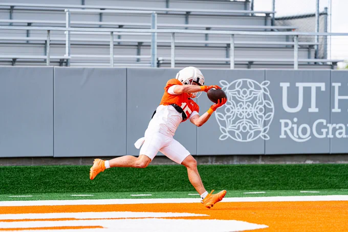 Player stretching out to catch a pass near the end zone.