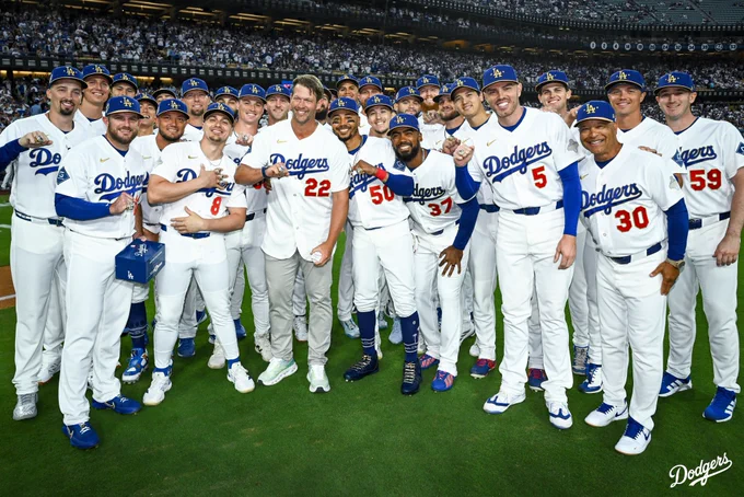 A team photo of the 2025 World Series Champions holding up their rings and posing for a photo on the field.