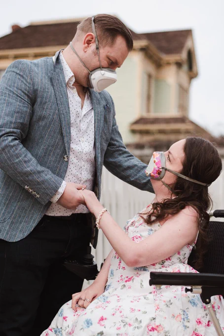 A white woman in her wheelchair wearing her Flo mask looking lovingly into her partner’s eyes, while he’s wearing his Flo mask.