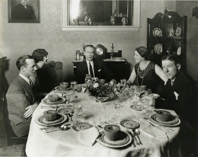 Image of dining room with five people in dressy garb, early 20th century. James Branch Cabell is the host of the dinner party and is sitting at the head position of the table. VCU Libraries/Special Collections and Archives.
