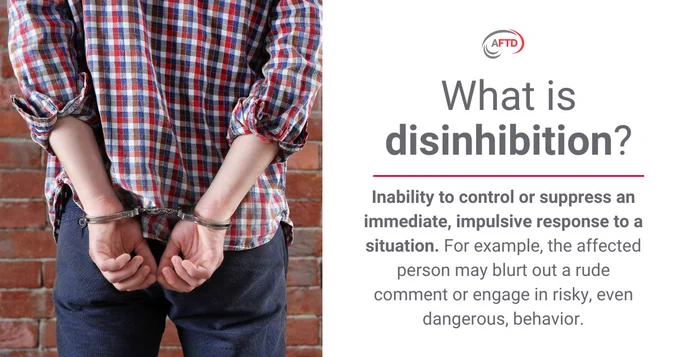 A person in handcuffs stands against a brick wall, wearing a plaid shirt and jeans. Text to the right reads: "What is disinhibition? Inability to control or suppress an immediate, impulsive response to a situation. For example, the affected person may blurt out a rude comment or engage in risky, even dangerous, behavior." The AFTD logo is present.