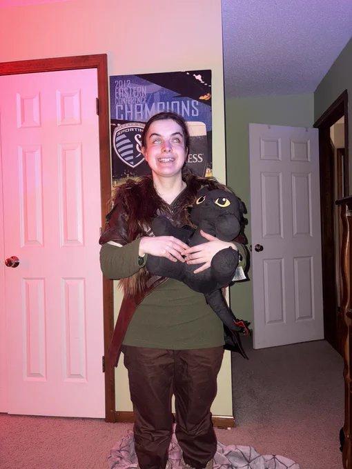 Me in my Hiccup cosplay smiling holding my Toothless Build-A-Bear!