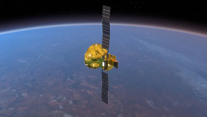 Un veicolo spaziale dorata e scintillante occupa il centro dell'immagine. I suoi due pannelli solari sono dispiegati uno verso l'alto e uno verso il basso. I pannelli non sono completamente distesi, ma presentano due lievi pieghe ciascuno. Sullo sfondo si vede la Terra, con l'orizzonte che si incurva da sinistra a destra nella parte superiore dell'immagine.