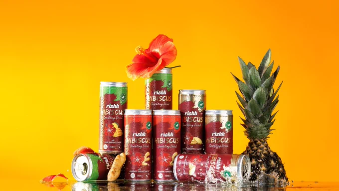 Landscape image of different flavours of Rishh Hibiscus drink. The image is styled using the drink ingredients; hibiscus, ginger, pineapple. The image is by Aisha Ife