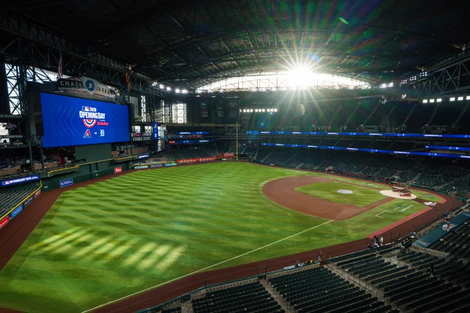 A photo of Chase Field from left field. You can see the sun rising and Opening Day branding on the scoreboard. 