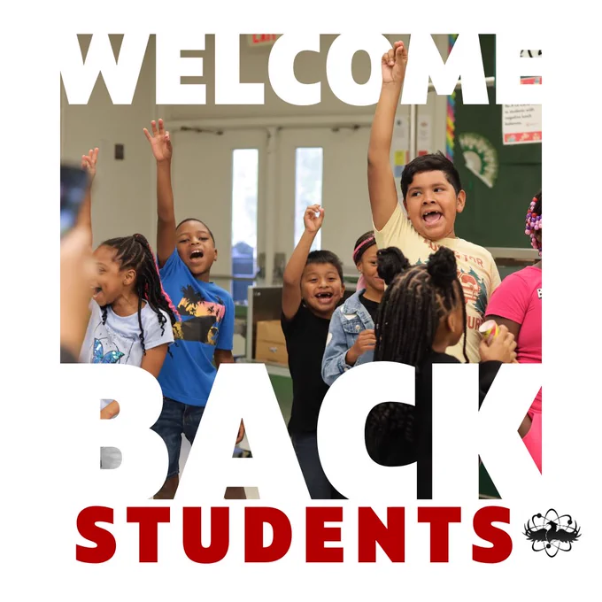 Group of young students eagerly raising their hands in a classroom setting during a welcome back event.