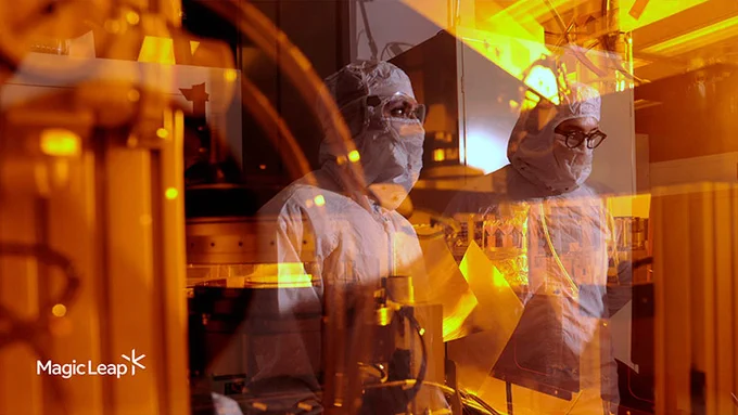 Technicians in the clean room surrounded by manufacturing equipment.