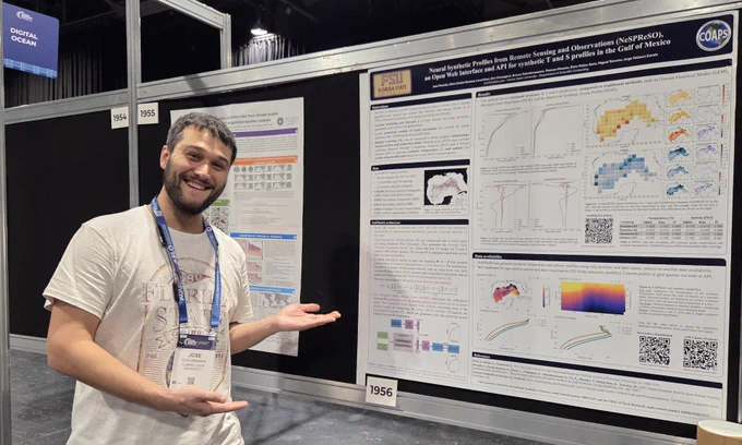 Photo of Jose Miranda smiling in front of his research poster.