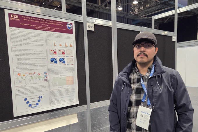 Photo of Jorge Velasco beside his research poster.