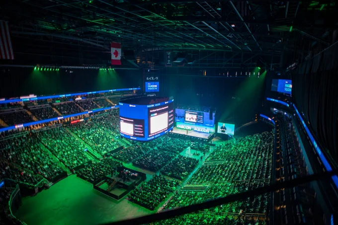 Event showcasing presentations on large digital displays in a packed arena.