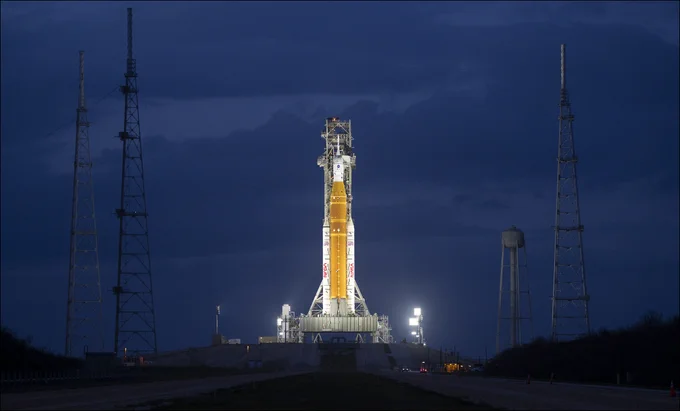 NASA’s Artemis II Space Launch System (SLS) rocket and Orion spacecraft are seen illuminated by spotlights atop a mobile launcher at Launch Complex 39B, Monday, March 30, 2026, as preparations continue for launch at NASA’s Kennedy Space Center in Florida. NASA’s Artemis II test flight will take Commander Reid Wiseman, Pilot Victor Glover, and Mission Specialist Christina Koch from NASA, and Mission Specialist Jeremy Hansen from the CSA (Canadian Space Agency), around the Moon and back to Earth no later than no later than April 2026. Photo Credit: (NASA/Joel Kowsky)