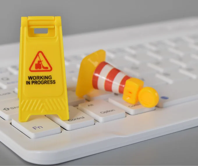 An image of a miniature traffic cone placed onto a computer keyboard.