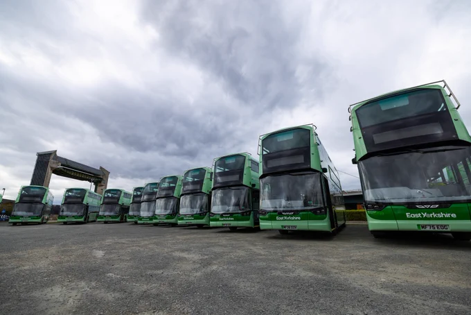 Several of Eat Yorkshire Buses' new electric vehicles in front of the Hull Tidal Barrier.