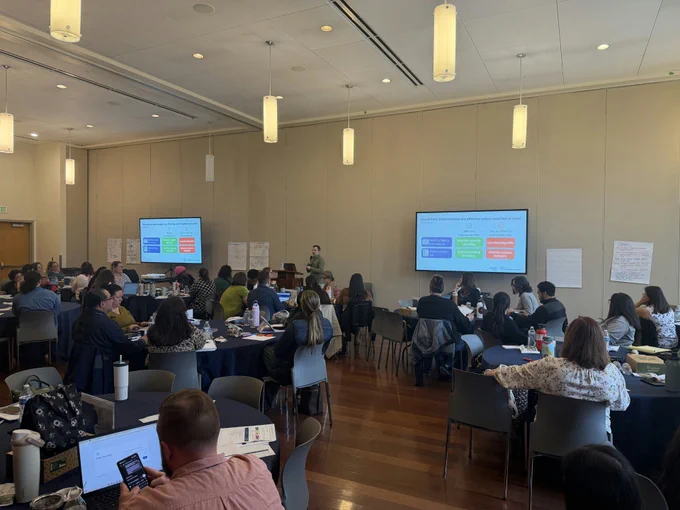Photo of presenter and participants in a large room