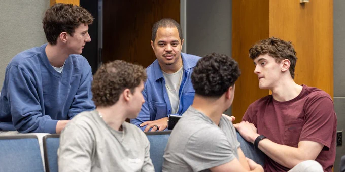 Professor Carl Suddler listens to students in a small group discussion during Emory College's Sports, Power and Society course