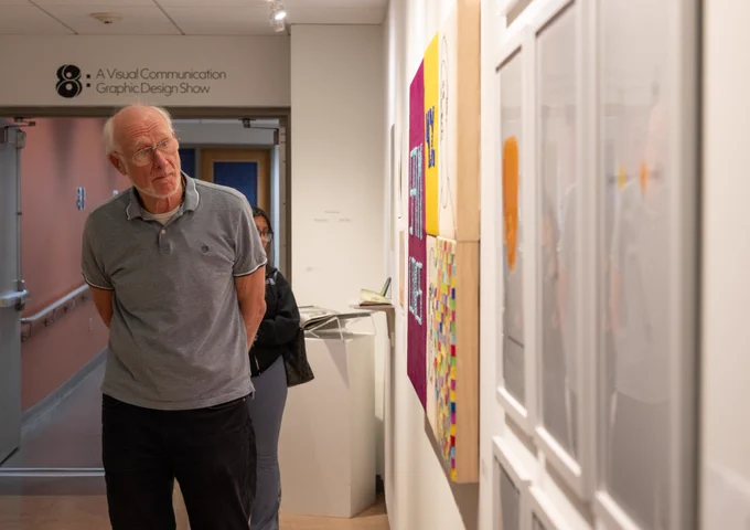 Photo of an individual looking at art pieces.