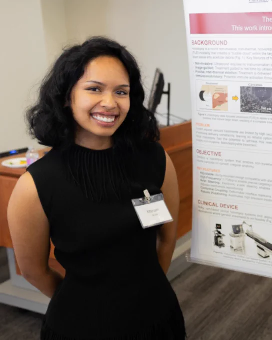 Mariam is standing in front of her poster.