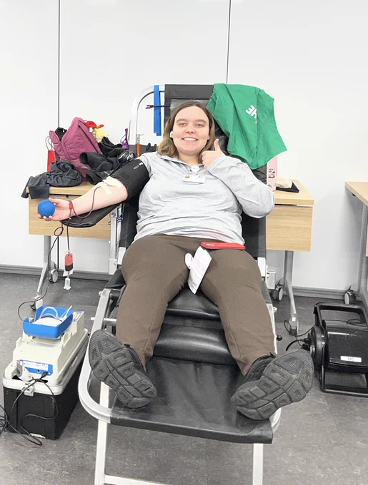 An AES Ohio employee reclines in a donation chair during a blood drive, with medical equipment beside the chair.