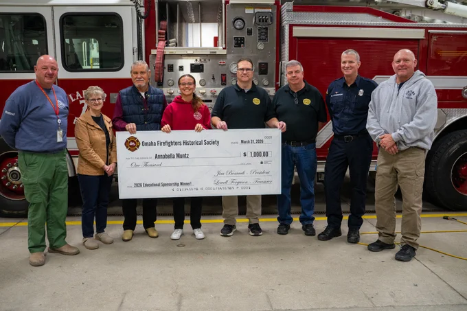 MCC Fire Science Academy student Annabella Muntz poses with oversized $1,000 scholarship check with MCC instructors and Omaha Firefighters Historical Society and Omaha Fire Department personnel. 
