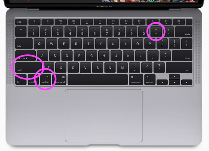 An image of a macbook keyboard with shift, option and dash keys highlighted with circles