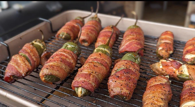 Jalapeño poppers filled with brisket and cream cheese wrapped in bacon and seasoned, slow smoked for 2 hours at 225
