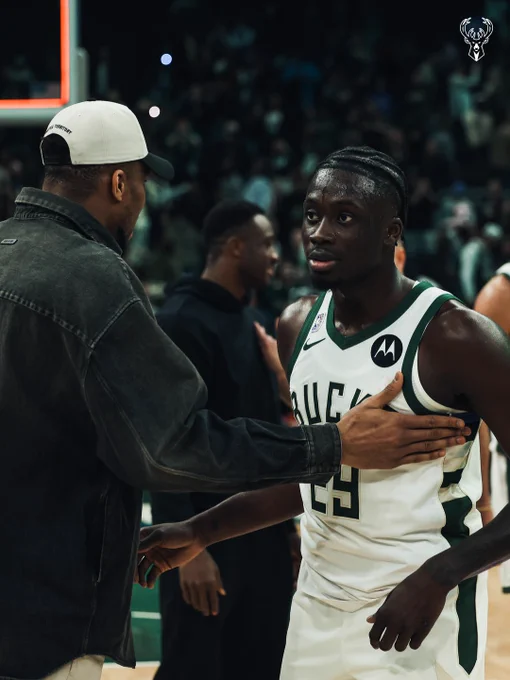 Brothers Giannis and Alex Antetokounmpo celebrating after a Bucks win at Fiserv Forum.